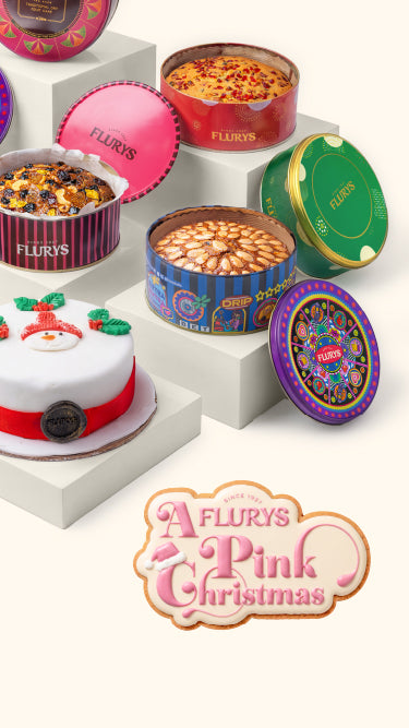 Assorted Flury's confectionery items including tins and a cake on a white background.